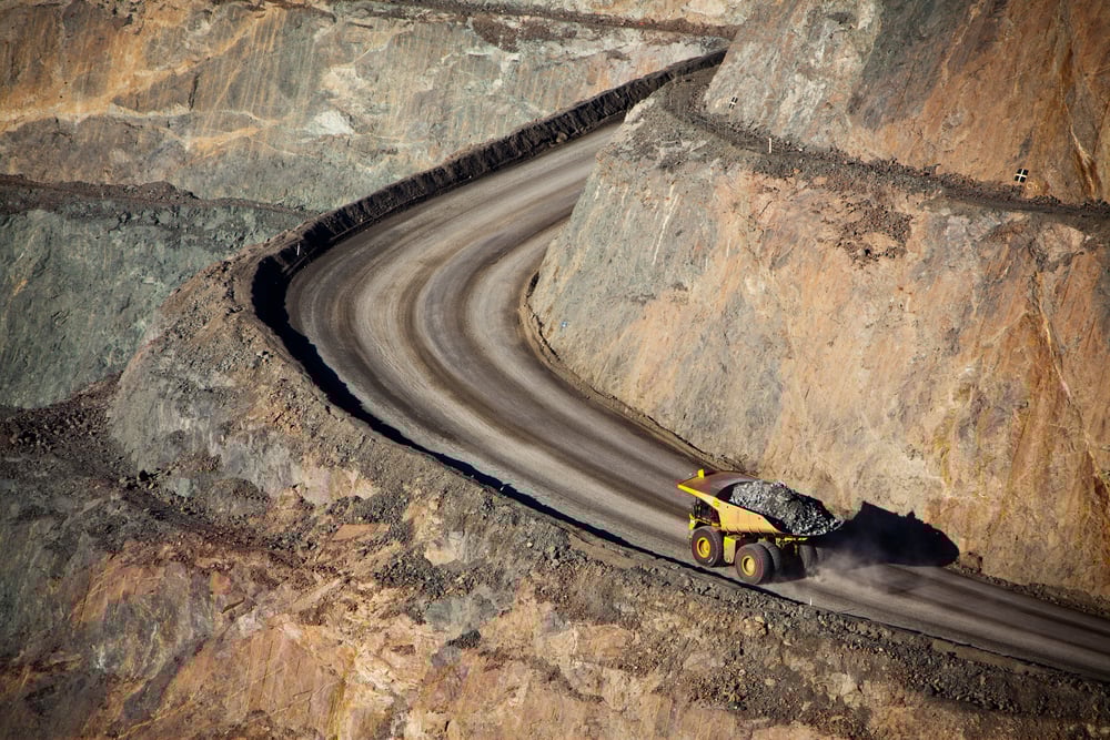 A loaded mining truck driving through a pit mine.